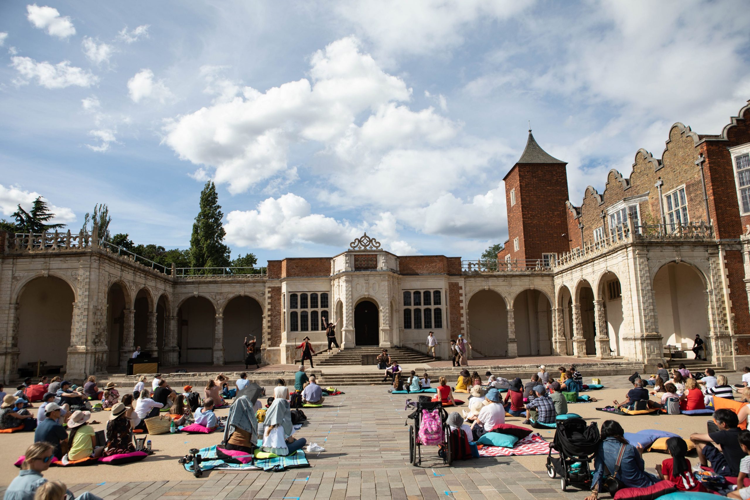 Socially distanced audience watches Pirates of Penzance outdoors on picnic blankets