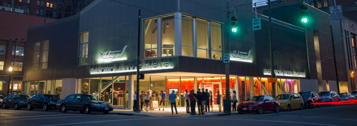 Exterior of Cincinnati Shakes at night with people mingling on sidewalk