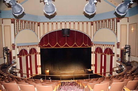 Lit stage with podium and desk at Grand Opera House in Dubuque, IA