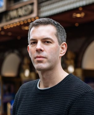 Chris Unitt, a man with dark hair, wears a black shirt