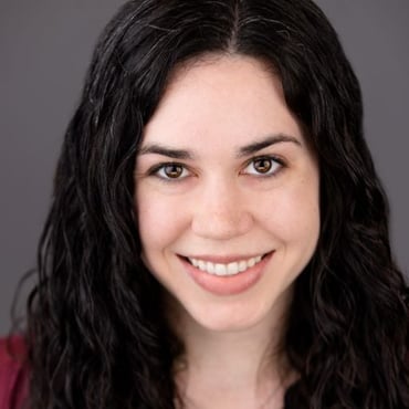 A headshot of Jennifer Sowinski Nemeth, a white woman with dark curly hair wearing a red shirt and smiling.