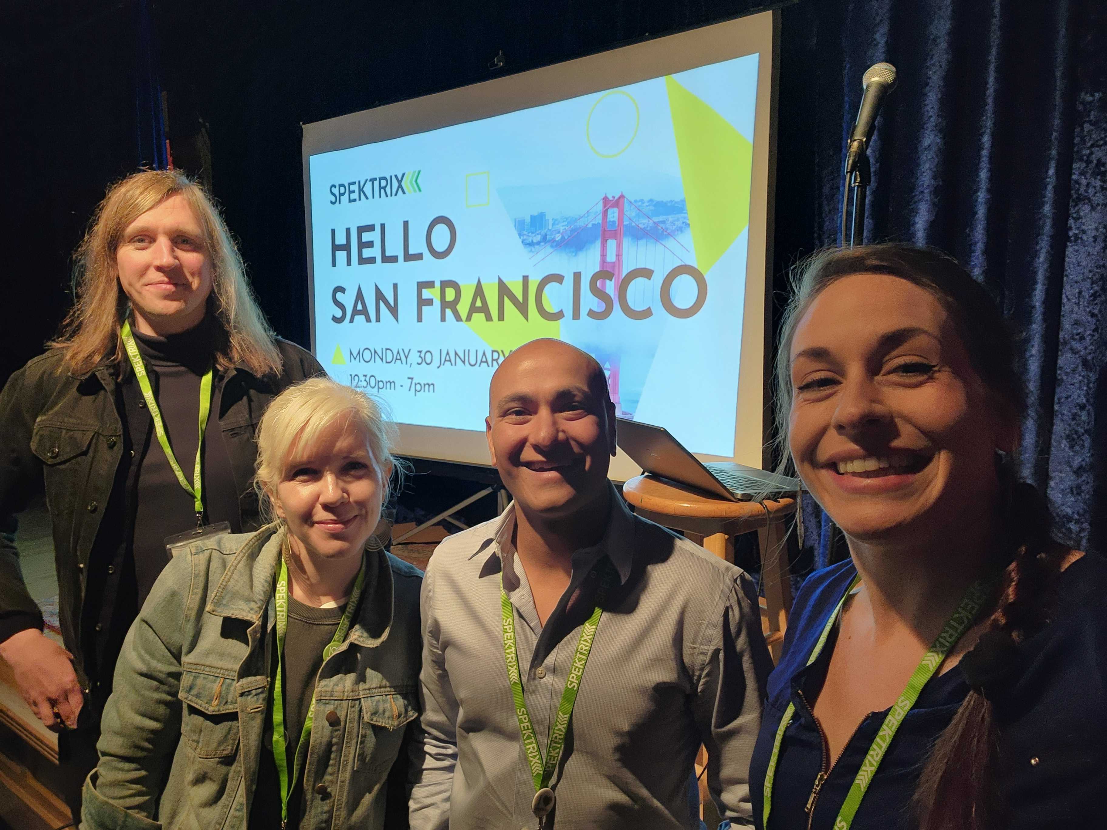Spektrix team members smile and wear matching green lanyards at Hubs in San Francisco