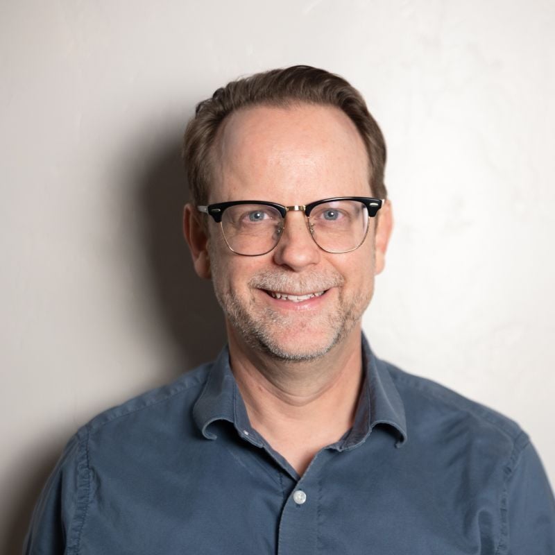 A picture of Tony Hall, Associate Director of Ticketing at Fox Tucson, wearing glasses and a blue collared shirt.