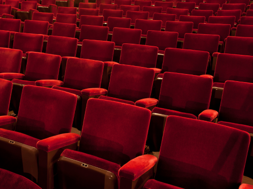 an image of rows of empty red theater seats