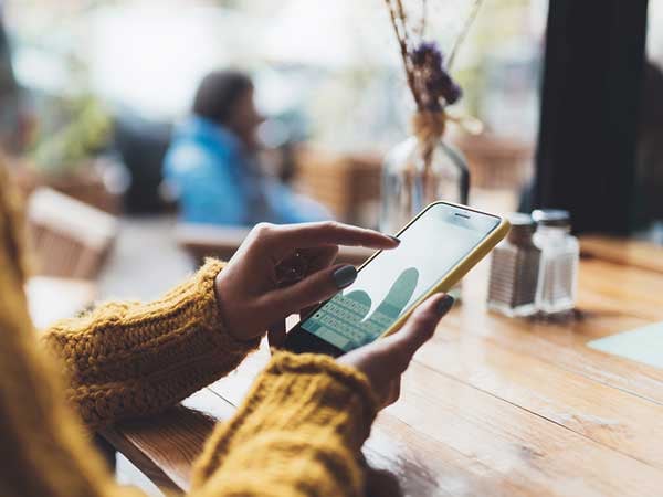 woman holding a smartphone and touching the screen