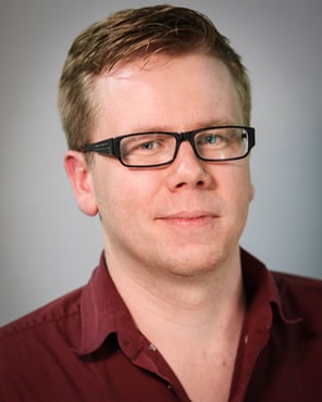 A headshot of Richard Bates, a fair haired white man with glasses