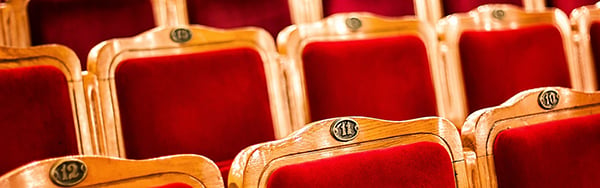 rows of wooden seats with red upholstering