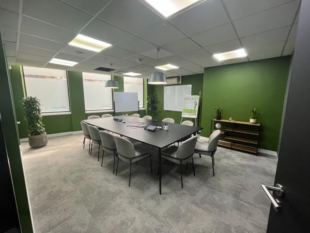 The shard, a meeting room in the Spektrix London office featuring green walls and a large central meeting table.