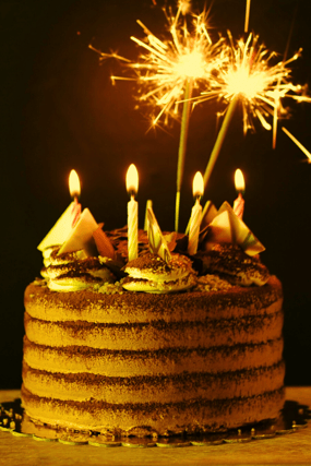 a celebratory cake with lit sparklers coming out of it