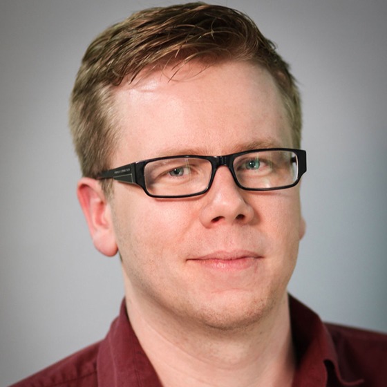 A headshot of Richard Bates, a fair haired white man with glasses