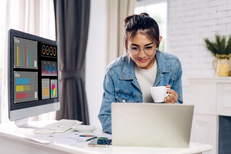 woman on computer with tea looking at analytics for how to build a dynamic pricing model