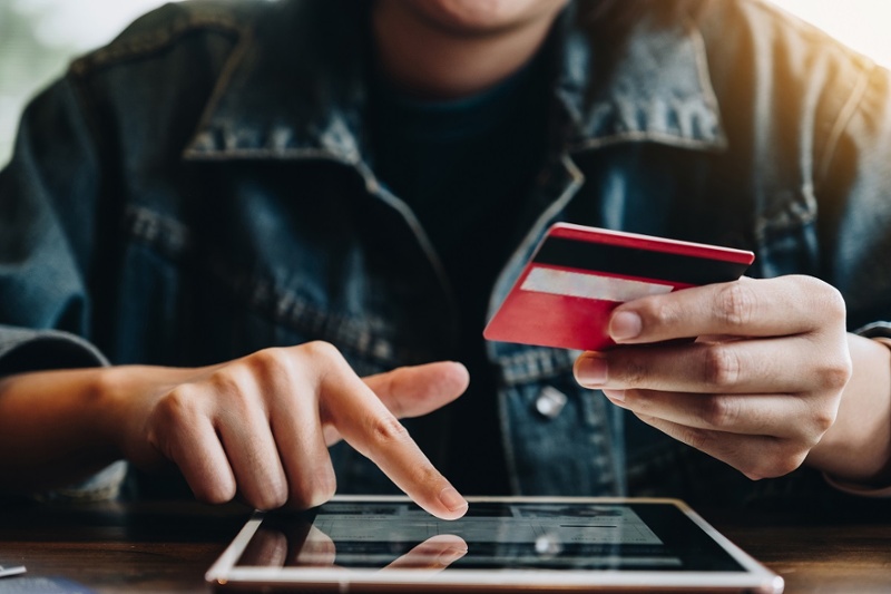 person purchasing with a credit card on a tablet