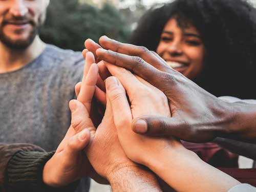 A diverse group of people holding hands.