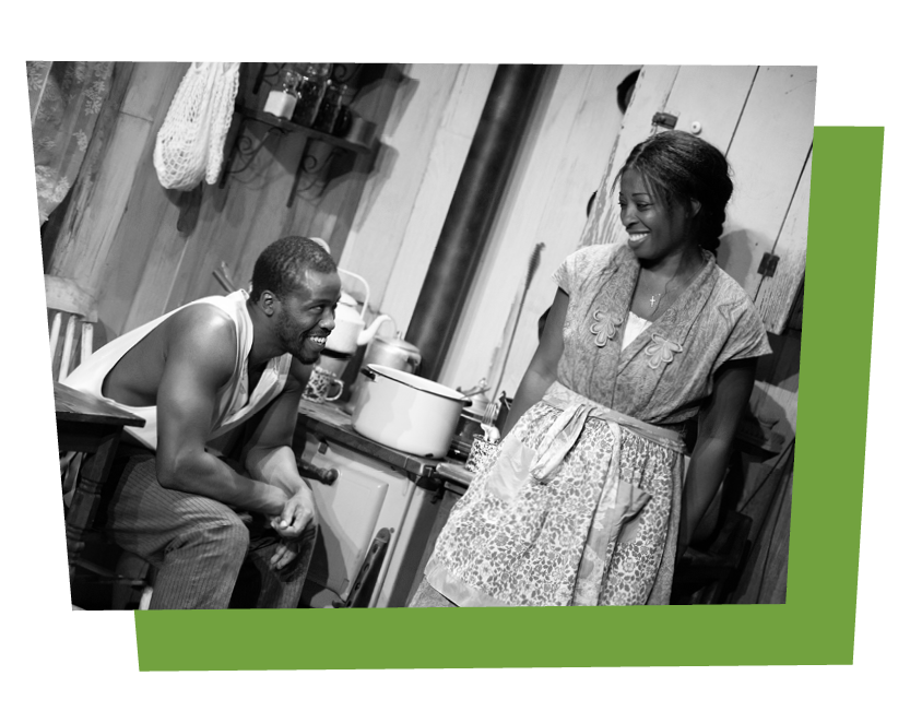 Male and female performers in conversation in a stage set like a 1950s American kitchen