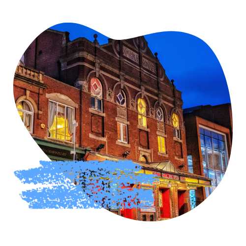 The facade of Theatre Royal Wakefield, a brick-built Victorian theatre, beneath a deep blue evening sky