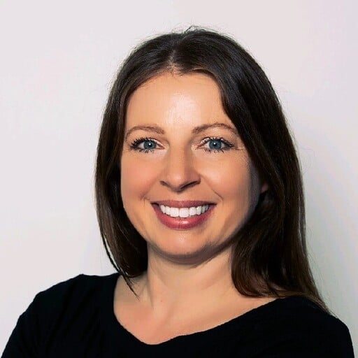 A portrait photo of a smiling Erin Caldwell with long, dark brown hair on a plain white backdrop.
