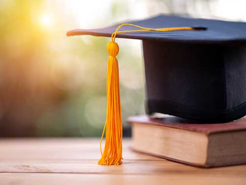 A graduation cap on a book. 