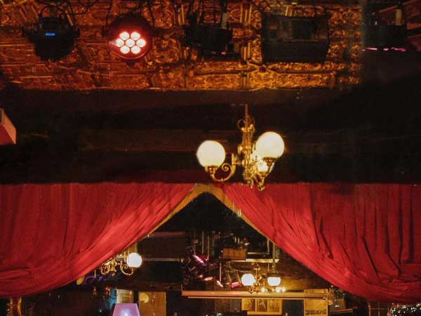 Red velvet swags and vintage lamps lit in a darkened Phoenix Arts Club