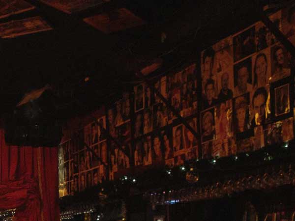 A wall of headshots hang in a darkened Phoenix Arts Club