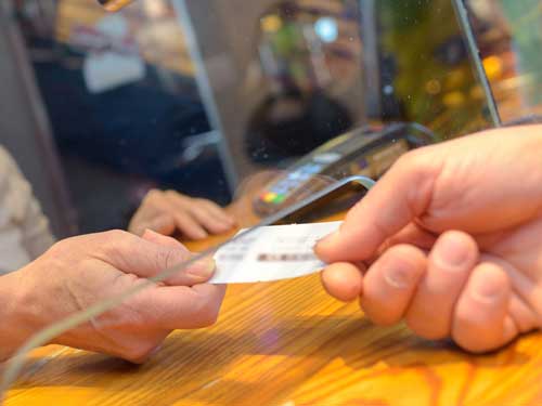 Paper ticket being passed through box office window