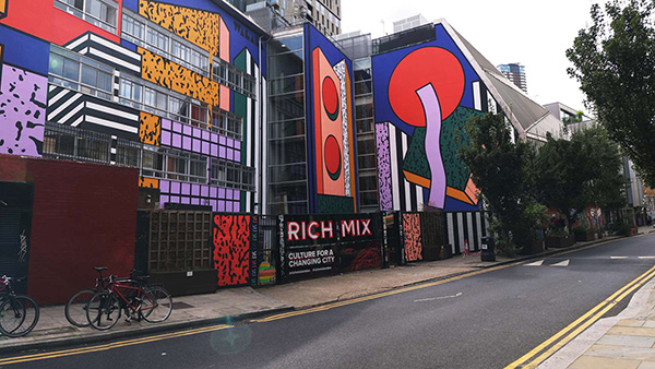 Exterior of Rich Mix music venue in London, with bright visuals decorating its glass walls