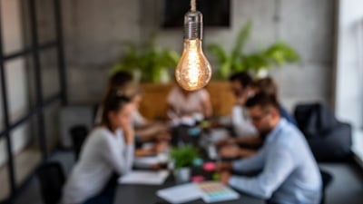 Young creative business people meeting at office focus on bare light bulb illuminated