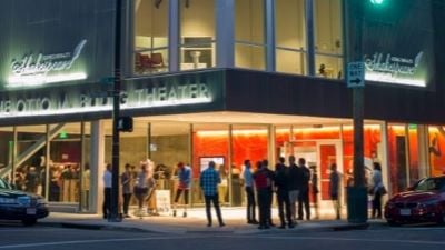 Exterior of Cincinnati Shakes at night with people mingling on sidewalk