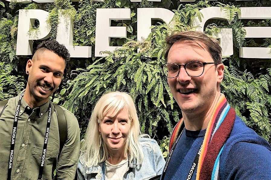 team members with a client in front of plant life at Climate Pledge Arena in Seattle