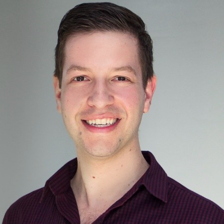 A headshot of Yosaif Cohain, a white man with short hair wearing a dark shirt 