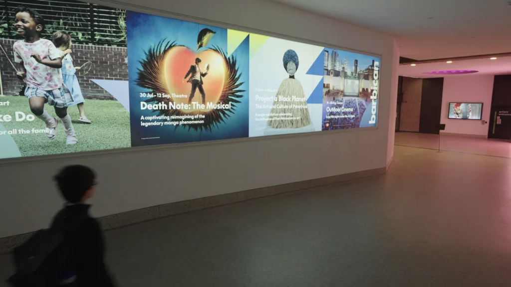 Barbican Corridor Digital Posters With Visitor
