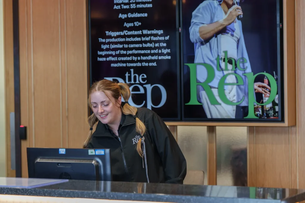 Binghamton Rep Box Office Worker Desk Smiling Ticketing