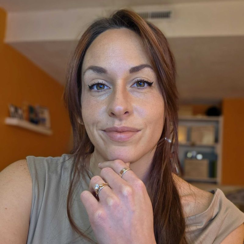 A Picture Of Karen Elizondo, A Woman With Brown Hair Wearing A Grey Shirt.
